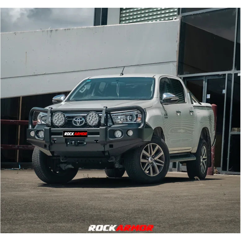 White pickup truck with aftermarket elite bull bar and fog lights on Toyota Hilux N80