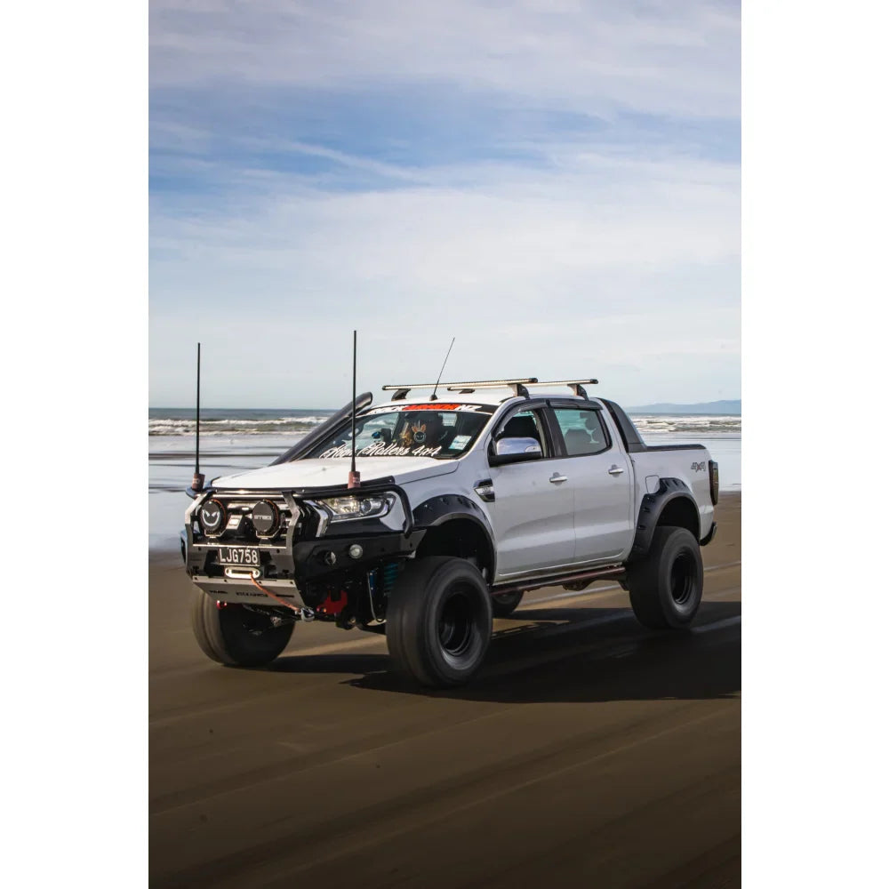 Modified white pickup truck with Rockarmor GT Steel Hoop Bullbar, driving lights, and fog lights