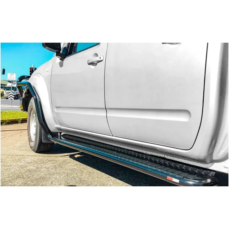 Silver Nissan Navara D40 with rockarmor steel rockslider side steps featuring black running boards and steel checker plate design